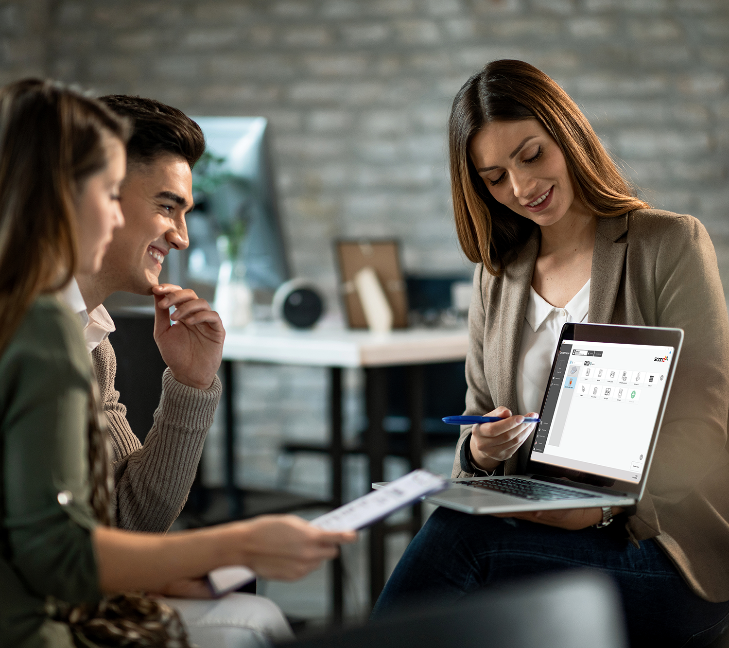smiling-real-estate-agent-using-computer-while-having-meeting-with-young-couple-making-investment-plans